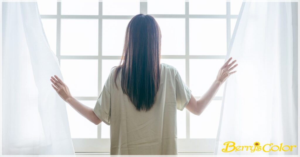 窓を開ける女性